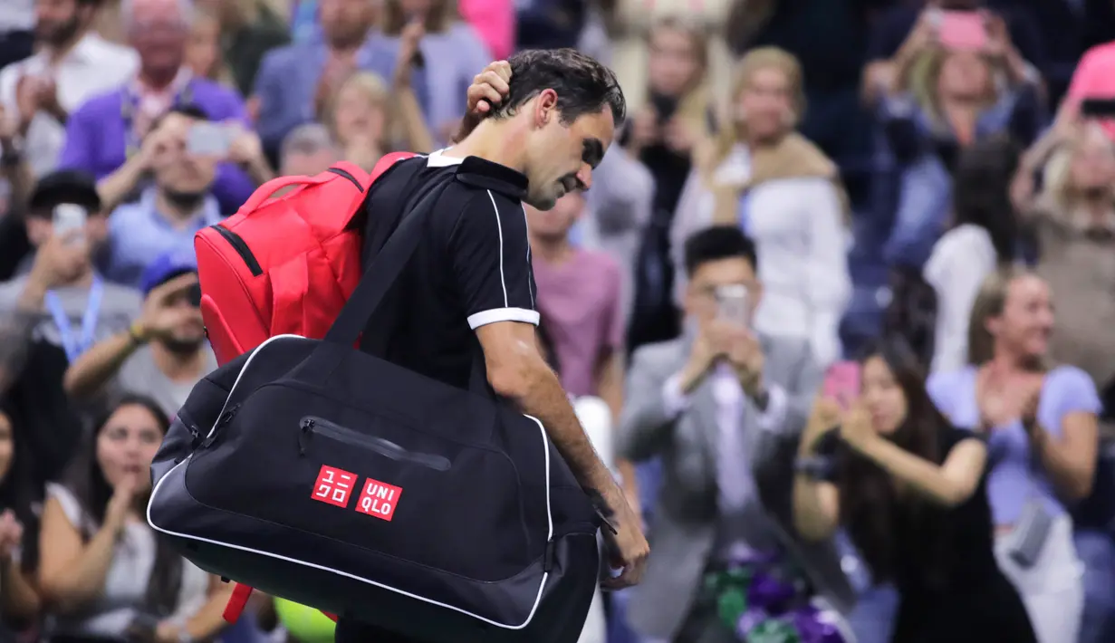Petenis Roger Federer tertunduk saat berjalan keluar lapangan usai kalah dari Grigor Dimitrov pada perempat final turnamen tenis AS Terbuka 2019 di New York, Amerika Serikat, Selasa (3/9/2019). Dimitrov menang 3-6, 6-4, 6-3, 6-4, 6-2. (AP Photo/Charles Krupa)