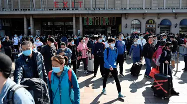 Orang-orang tiba di stasiun kereta api Beijing pada hari terakhir libur nasional "golden week", Kamis (7/10/2021). Liburan yang kerap disebut sebagai The Golden Week Holiday ini adalah peringatan berdirinya Republik Rakyat China pada tahun 1949. (JADE GAO / AFP)