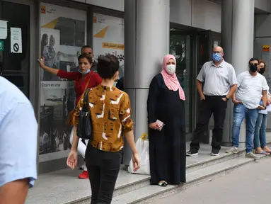Orang-orang yang mengenakan masker mengantre untuk memasuki pasar swalayan di Tunis, Tunisia, pada 5 Oktober 2020. Perdana Menteri Tunisia Hichem Mechichi pada 3 Oktober mengumumkan serangkaian langkah untuk membatasi penyebaran cepat COVID-19 di negara tersebut. (Xinhua/Adel Ezzine)