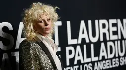 Penyanyi Lady Gaga saat berpose saat menghadiri fashion show koleksi Saint Laurent di Hollywood Palladium, California, (10/2).  Dengan mengenakan kemeja putih ditambah dengan jaket berwarna gold membuatnya tampak macho. (REUTERS / Mario Anzuoni)