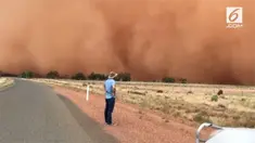 Sebuah keluarga menyaksikan secara langsung badai pasir melanda wilayah pedalaman Australia. Fenomena tersebut membuat warna langit berubah menjadi oranye.
