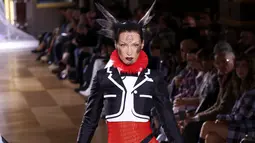 Bella Hadid mempersembahkan kreasi Thom Browne saat peragaan busana Musim Semi-Musim Panas 2023 sebagai bagian dari Paris Womenswear Fashion Week, Paris, Prancis, 3 Oktober 2022. Model berusia 25 tahun ini tampak luar biasa dalam balutan busana merah, hitam, dan putih yang terinspirasi dari adibusana kartun. (Photo by Vianney Le Caer/Invision/AP)