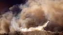 Sebuah helikopter pemadam kebakaran melakukan upaya pemadaman di atas kebakaran gunung (mountain fire) yang menghanguskan puluhan hektar lahan di Santa Paula, California, pada tanggal 7 November 2024. (ETIENNE LAURENT/AFP)