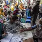 Warga menunggu giliran untuk menerima dosis vaksin booster COVID-19 Pfizer di Surabaya, Jawa Timur, Kamis (13/1/2022). (JUNI KRISWANTO/AFP)