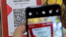 QRIS adalah standar kode QR (Quick Response) yang digunakan di Indonesia untuk menghubungkan dompet digital dan metode pembayaran non-tunai dengan berbagai pihak, termasuk bank dan pedagang. (Liputan6.com/Johan Tallo)