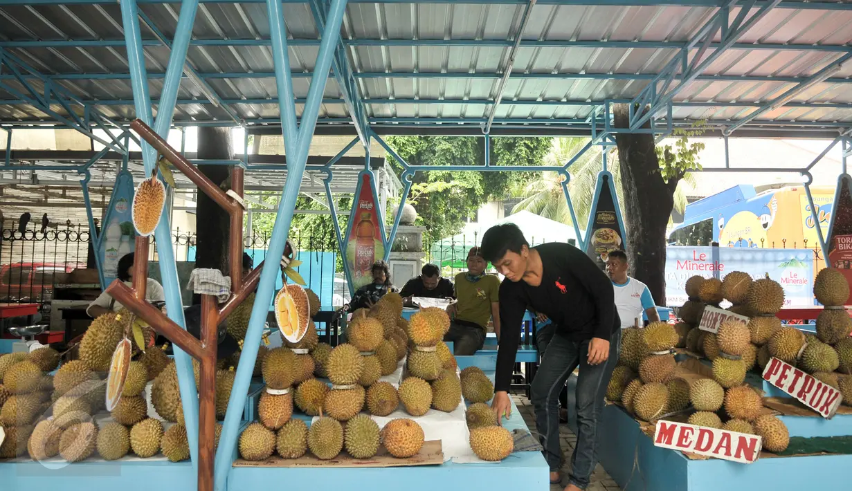 Pedagang merapihkan durian daganganya di Lokasi Sementara (Loksem) Pusat Penjualan Durian, Jalan TMP Kalibata, Jakarta Selatan, Kamis (9/2). Pemprov DKI Jakarta bangun Loksem Pusat Penjualan Durian di Kalibata. (Liputan6.com/Yoppy Renato)