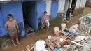 Warga mebersihkan sisa-sisa endapan lumpur di rumahnya, Cawang, Jakarta, Senin (7/11). Sebelumnya, ratusan rumah warga di RW 02 Cawang, Kramat Jati, Jakarta Timur tergenang akibat banjir kiriman dari kawasan Bogor. (Liputan6.com/Yoppy Renato)