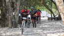 Para pebalap melintasi trek berpasir Mountain Bike Cross Country Marathon pada Festival Pesona Tanjung Lesung 2017 di Tanjung Lesung, Banten (23/9/2017). MTB XCM tersebut menempuh jarak 48 km. (Bola.com/Nicklas Hanoatubun)