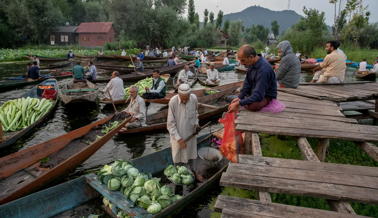 Para pria Kashmir menjual produk mereka di pasar sayur terapung di Danau Dal di Srinagar, Kashmir yang dikuasai India pada 26 Juli 2020. Sayuran yang diperdagangkan di pasar terapung ini disuplai ke Srinagar dan banyak kota di lembah Kashmir. (AP Photo/Dar Yasin)