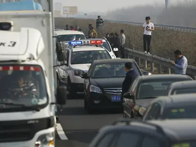 Sejumlah pengendara terlihat berdiri di pinggir jalan saat kendaraan mereka terjebak kemacetan parah di Jinji Expressway, antara Beijing-Tianjin, China, Rabu (2/3). (REUTERS/Kim Kyung - Hoon)