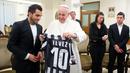 Paus Fransiskus memegang jersey dari pemain Juventus, Carlos Tevez selama audiensi pribadi di Vatican 12 November 2013. (AFP/Osservatore Romano)