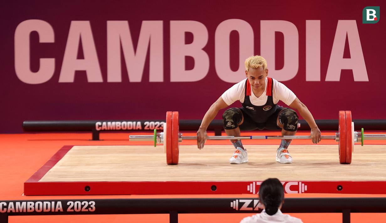 <p>Atlet angkat besi Indonesia, Eko Yuli Irawan berkompetisi pada nomor angkat besi putra 61 kg SEA Games 2023 di Taekwondo Hall Olympic Complex, Phnom Penh, Kamboja, Sabtu (13/05/2023). (Bola.com/Abdul Aziz)</p>
