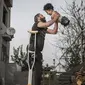 Pria Suriah yang Menggendoong Bocah Tanpa Kaki dan Tangan (Foto: Siena International Photography Awards/Mehmet Aslan)