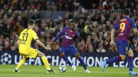 Penyerang Barcelona, Ousmane Dembele (tengah) berusaha melewati pemain Borrusia Dortmund, Julian Weigl pada pertandingan Grup F Liga Champions di stadion Camp Nou, Spanyol (27/11/2019). Barcelona menang 3-1 atas Dortmund. (AP Photo/Joan Monfort)
