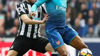 Pemain Newcastle United, Paul Dummett (kiri) berusha merebut bola yang dibawa pemain Arsenal, Alex Iwobi saat bertanding pada lanjutan Liga Inggris di St James 'Park, (15/4). Newcastle menang atas Arsenal 2-1. (Owen Humphreys/PA via AP)