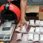 Petugas menata barang bukti saat merilis sejumlah kasus peredaran narkoba di Polda Metro Jaya, Jakarta, Rabu (11/1). Dari penangkapan 11 WNI dan 1 Warga Negara Nigeria disita sebanyak 2,2 kg sabu dan 26.560 butir pil ekstasi. (Liputan6.com/Yoppy Renato)