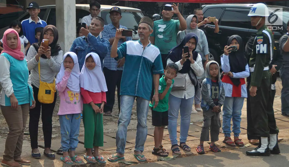 Warga sekitar Puri Cikeas bersiap menyambut iring-iringan kepergian jenazah Ani Yudhoyono menuju TMP Kalibata, Bogor, Jawa Barat, Minggu (2/6/2019). Ani Yudhoyono wafat pada 1 Juni 2019 pukul 11.50 di Singapura. (Liputan6.com/Immanuel Antonius)