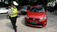 Polantas Polres Depok memeriksa surat tanda nomor kendaraan (STNK) saat Operasi Gabungan Tertib Administrasi Kendaraan Bermotor (KBM) Kendaraan Tidak Mendaftar Ulang (KTMDU) 2022 di Jembatan Panus, Depok, Kamis (9/6/2022). Ratusan kendaraan bermotor yang belum membayar pajak atau kendaraan tidak melakukan daftar ulang (KTMDU) terjaring dalam razia yang dilakukan Sistem Administrasi Manunggal Satu Atap (Samsat) Depok ini. (merdeka.com/Arie Basuki)