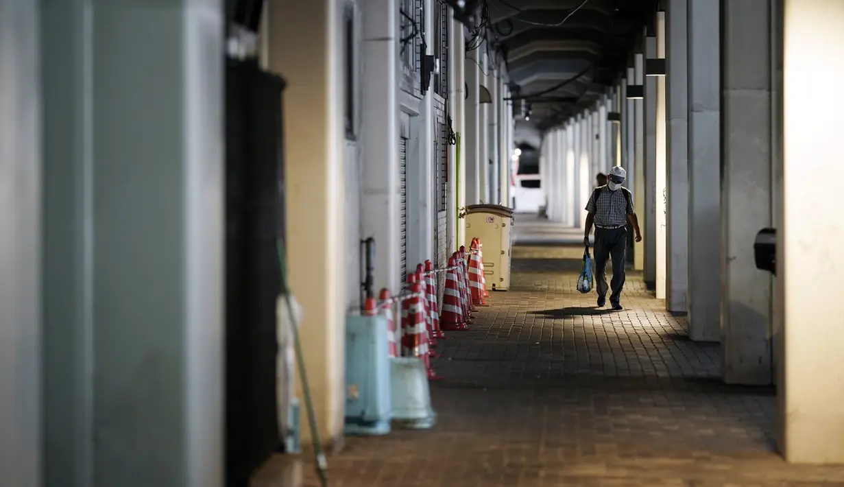 Seorang pria yang mengenakan masker untuk mencegah penyebaran Covid-19 berjalan di sepanjang jalan bawah tanah di Tokyo, Selasa (1/9/2020). Ibukota Jepang mengonfirmasi lebih dari 170 kasus virus korona pada hari Selasa. (AP Photo/Eugene Hoshiko)