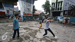 Seorang remaja saat mengiring bola saat bermain di kolong rel kereta kawasan Juanda, Jakarta, Jumat (27/5). Tidak tersedianya ruang terbuka menyebabkan lahan tersebut dijadikan tempat bersosialisasi bagi warga. (Liputan6.com/Immanuel Antonius)