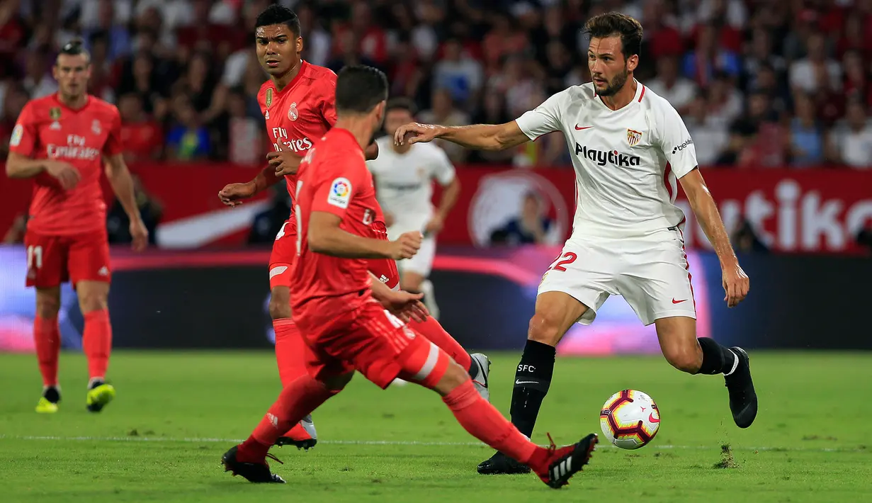 Pemain Sevilla, Franco Vazquez membawa bola dari kawalan bek Real Madrid Nacho saat bertanding pada lanjutan La Liga Spanyol di stadion Sanchez Pizjuan (26/9).  Sevilla menang telak 3-0 atas Madrid. (AP Photo/Miguel Morenatti)