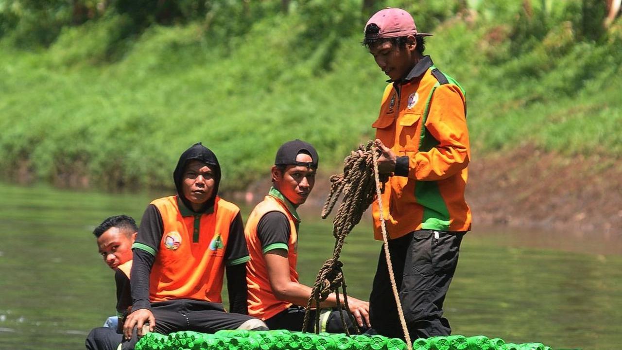 Petugas UPS Badan Air saat melakukan uji coba ketahanan dan keseimbangan perahu botol plastik bekas di aliran KBT. Foto: merdeka.com / Imam Buhori