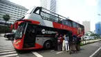 Warga antre untuk menaiki bus tingkat Transjakarta dengan atap terbuka di Jakarta, Selasa (10/5/2022). Selama libur Lebaran, bus wisata tersebut melayani warga menuju berbagai rute destinasi wisata Ibu Kota. (merdeka.com/Imam Buhori)