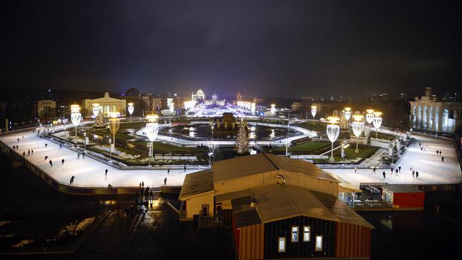 Suasana saat sejumlah orang berseluncur dalam pembukaan arena seluncur es di VDNKh (Pameran Prestasi Ekonomi Nasional), Moskow, Rusia, Jumat (27/11/2020). Area tersebut terbuat dari lapisan es buatan lebih dari 20.000 meter persegi. (AP Photo/Alexander Zemlianichenko)