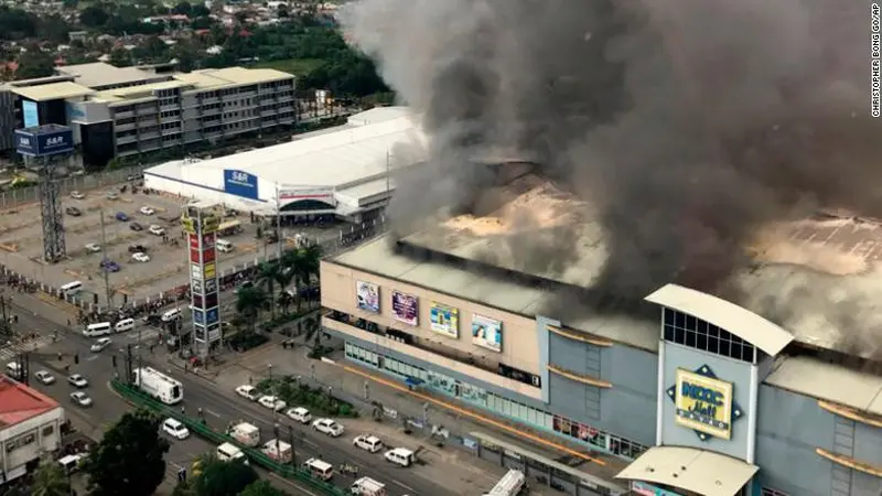 Pusat perbelanjaan yang terbakar di Davao, Filipina (23/12/2017). Hingga Minggu, 24 Desember 2017, petugas masih berusaha api yang berkobar (Christopher Bong/AP)