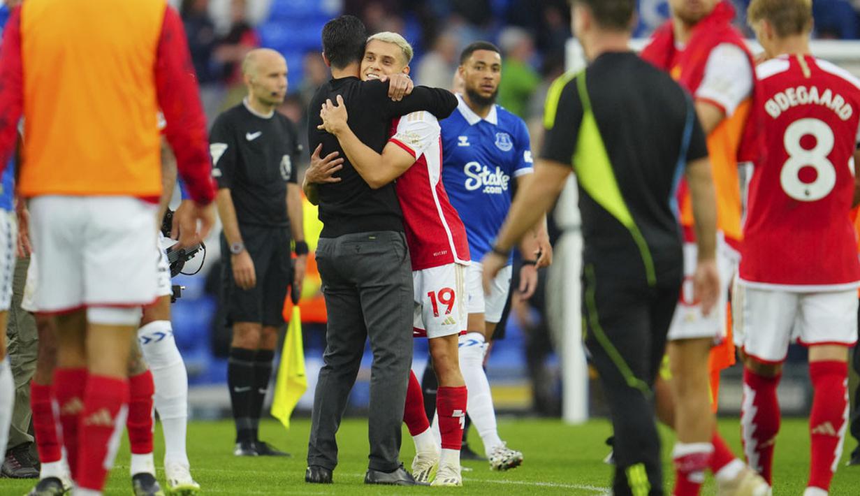 Pemain Arsenal, Leandro Trossard, dipeluk Mikel Arteta setelah laga melawan Everton pada laga Liga Inggris di Stadion Goodison Park, Minggu (17/09/2023). Berkat hasil ini, Arsenal sukses naik ke peringkat empat dengan poin 13 sekaligus meneruskan tren unbeaten mereka di awal musim ini. (AP Photo/Jon Super)
