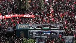 Sebuah truk yang membawa peti jenazah Pemimpin Tertinggi Iran Ayatollah Ali Khamenei dan anggota keluarganya melintas di tengah kerumunan pelayat selama prosesi pemakaman di Teheran, Iran, Senin, 6 Juli 2026. (AFP)