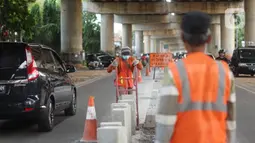 Pekerja menyelesaikan pembuatan separator atau pembatas jalan di Jalan Margasatwa, Andara, Jakarta Selatan, Kamis (21/11/2019). Separator itu dibuat guna memisahkan dua lajur sehingga meminimalisasi tingkat kecelakaan. (Liputan6.com/Immanuel Antonius)