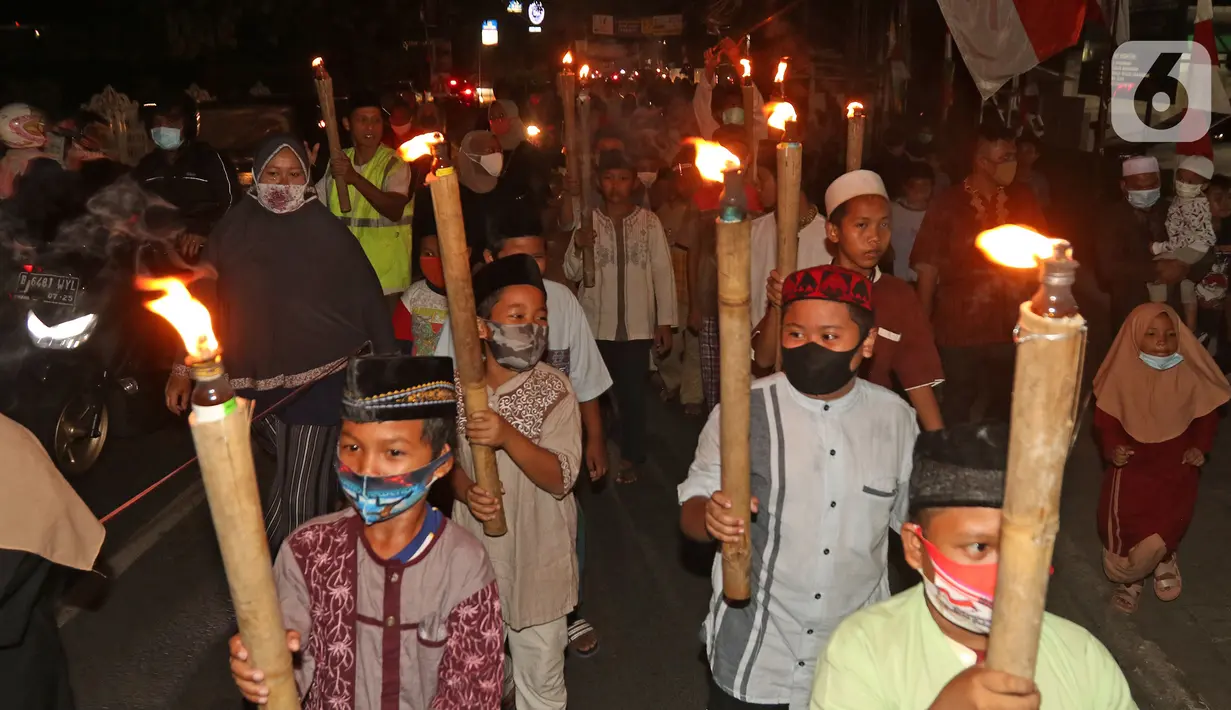 Sejumlah warga saat melakukan pawai obor di Kawasan Rempoa, Tangerang Selatan, Rabu (19/08/2020). Pawai obor tersebut dilakukan dalam rangka menyambut peringatan tahun baru Islam 1 Muharram 1442 H. (Liputan6.com/Herman Zakharia)