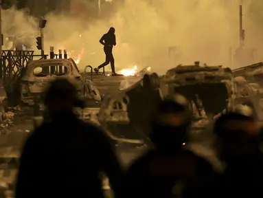 Seorang demonstran berlarian pada malam ketiga protes yang dipicu oleh penembakan fatal polisi terhadap seorang pengemudi berusia 17 tahun di Nanterre, Prancis, Jumat (30/6/2023). (AP Photo/Aurelien Morissard)
