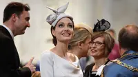 Aktris Angelina Jolie menghadiri acara Service of Commemoration and Dedication St Michael & St George di Katedral St. Paul, London, Kamis (28/6). Angelina Jolie terlihat memukau dalam balutan midi dress abu-abu yang super anggun. (Leon Neal/PA via AP)