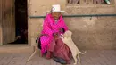 Julia Flores Colque bermain dengan salah satu anjing peliharaan keluarga di luar rumahnya di Sacaba, Bolivia, 23 Agustus 2018. Namun sayang, museum Guinness World Records belum berencana memasukkan nama Julia sebagai manusia tertua. (AP/Juan Karita)