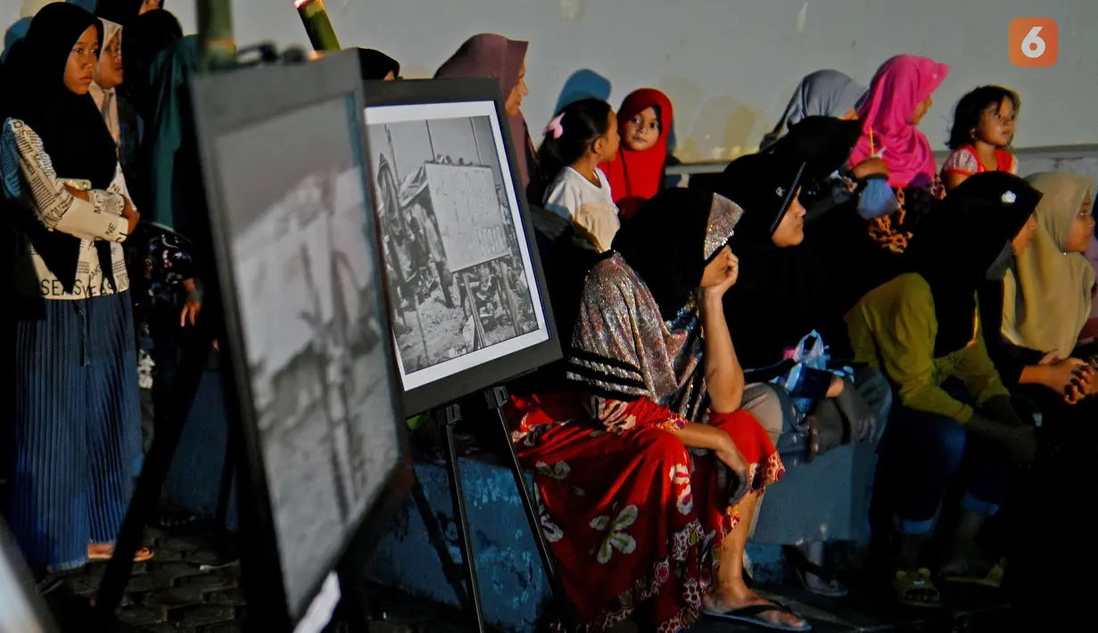 Sejumlah warga menghadiri upacara doa pada malam peringatan 17 tahun tsunami Boxing Day 2004 di monumen Kapal Tsunami Lampulo di Banda Aceh (25/12/2021). (AFP/Chaideer Mahyuddin)
