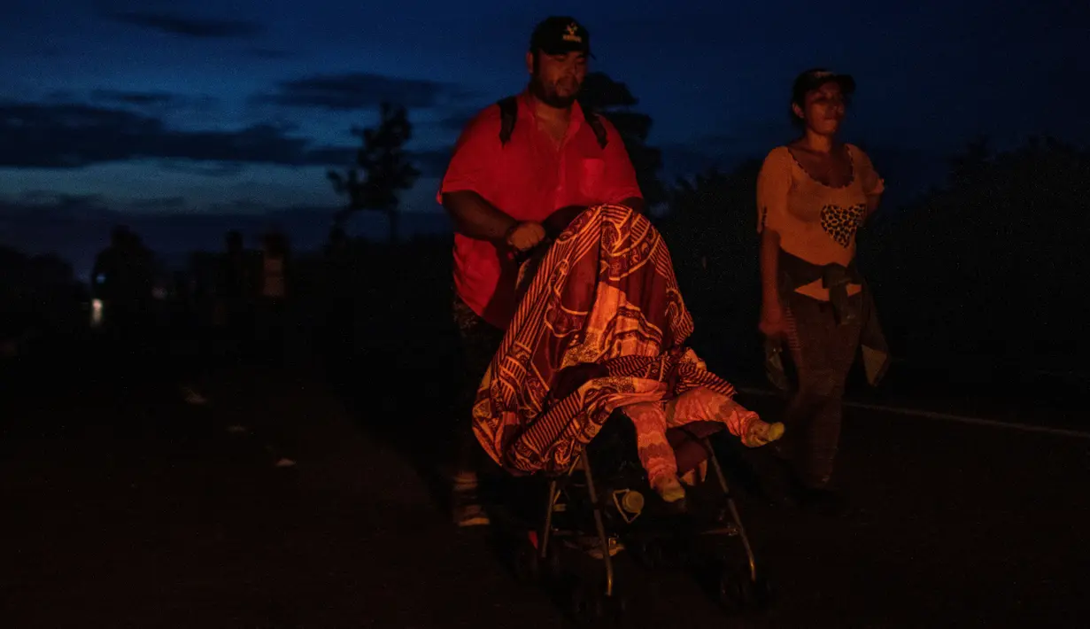 Imigran Honduras mendorong kereta bayi dalam perjalanannya menuju Amerika Serikat di Oaxaca, Meksiko, 29 Oktober 2018. Kereta dorong bayi tak hanya untuk balita mereka, tetapi juga dapat digunakan untuk membawa barang-barang. (Guillermo Arias/AFP)