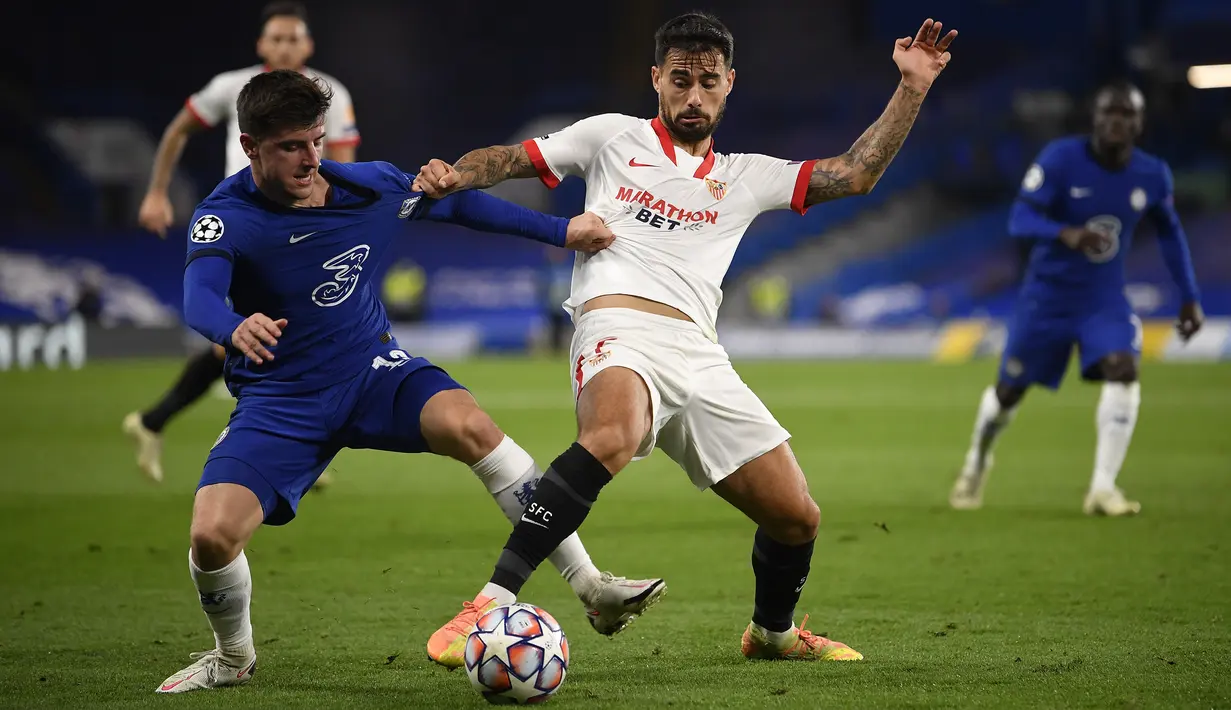 Gelandang Chelsea, Mason Mount, berebut bola atas dengan penyerang Sevilla, Suso, pada laga Grup E Liga Champions 2020/2021 di Stamford Bridge, Rabu (21/10/2020) dini hari WIB. Chelsea bermain imbang 0-0 atas Sevilla. (AFP/Toby Melville/pool)