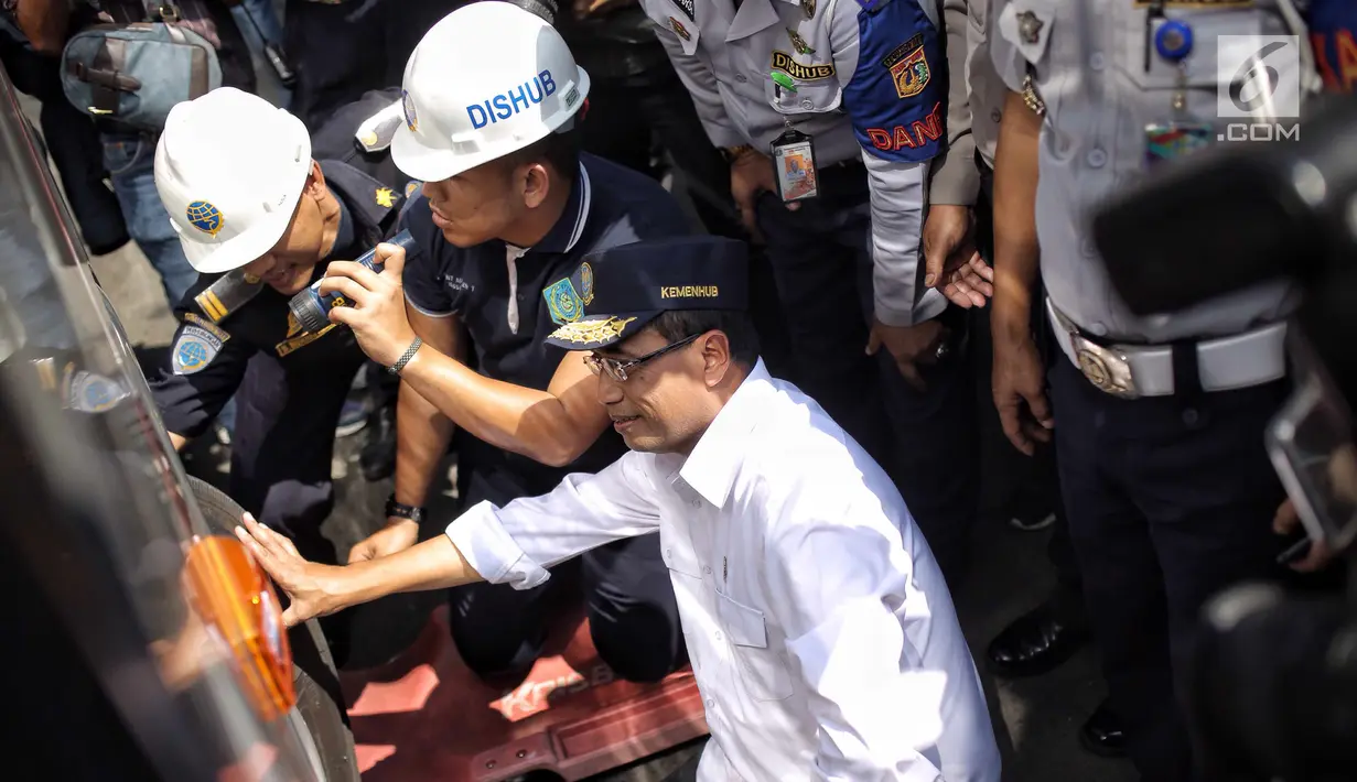 Menhub Budi Karya Sumadi mengecek ban bus penumpang saat meninjau kesiapan arus balik Lebaran di Terminal Kampung Rambutan, Jakarta, Selasa (19/6). Menurut Budi, pelaksanaan mudik di Terminal Kampung Rambutan sudah cukup baik. (Liputan6.com/Faizal Fanani)