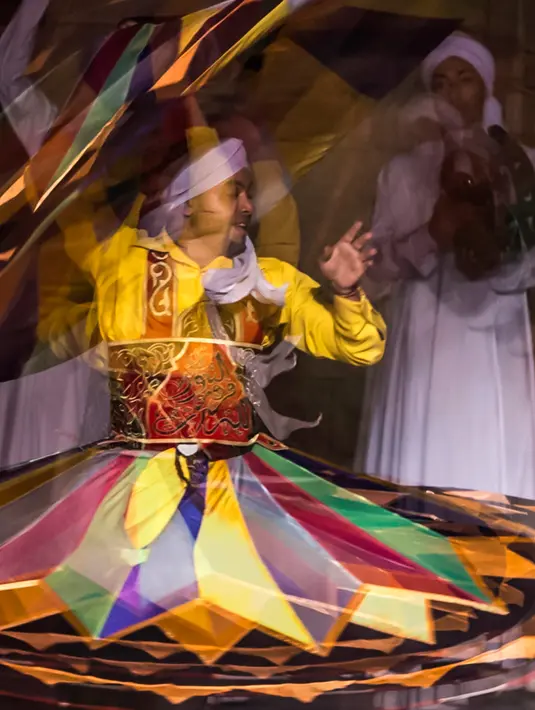 Penari Mesir membawakan tari Tanoura selama bulan Ramadan di istana budaya El-Ghuri, Kairo, 22 Mei 2018. Tanoura merupakan rok, yang dipakai penari kemudian ditarikan dengan tarian memutar-mutarkan tubuhnya sepanjang tarian. (AFP/KHALED DESOUKI)