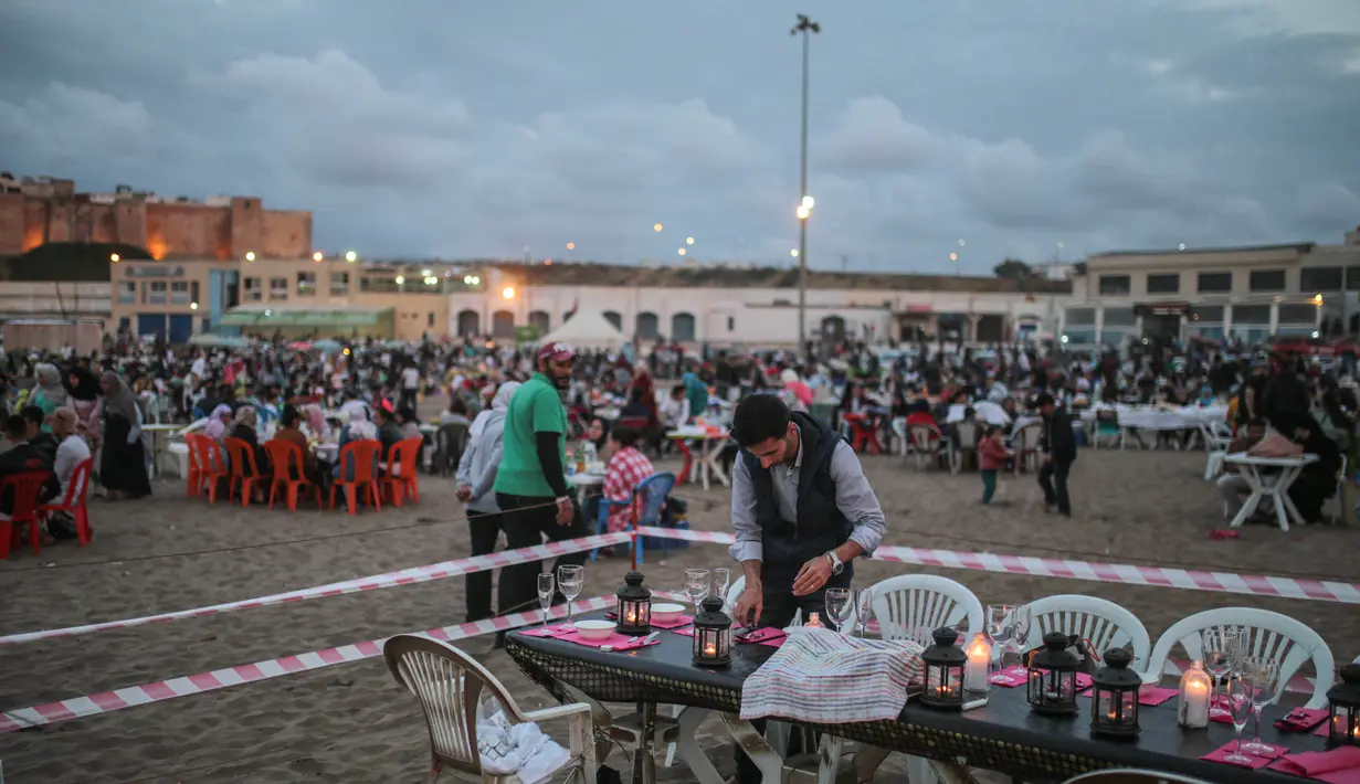 Warga menyiapkan makanan untuk buka di pantai Rabat, Maroko (9/6). Selama Ramadan, banyak warga Maroko berkunjung ke pantai menikmati angin Atlantik dan menikmati pemandangan laut. (AP Photo/Mosa'ab Elshamy)