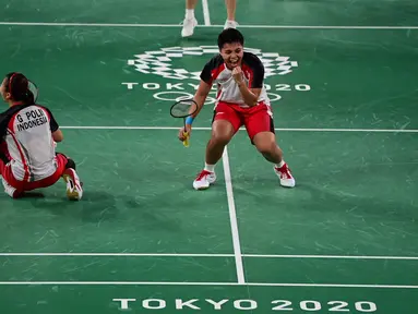 Reaksi ganda putri Indonesia Apriyani Rahayu dan Greysia Polii saat melawan Chen Qing Chen dan Jia Yi Fan dari China pada final badminton ganda putri Olimpiade Tokyo 2020 di Musashino Forest Sport, Senin (2/8/2021). (Pedro PARDO/AFP)