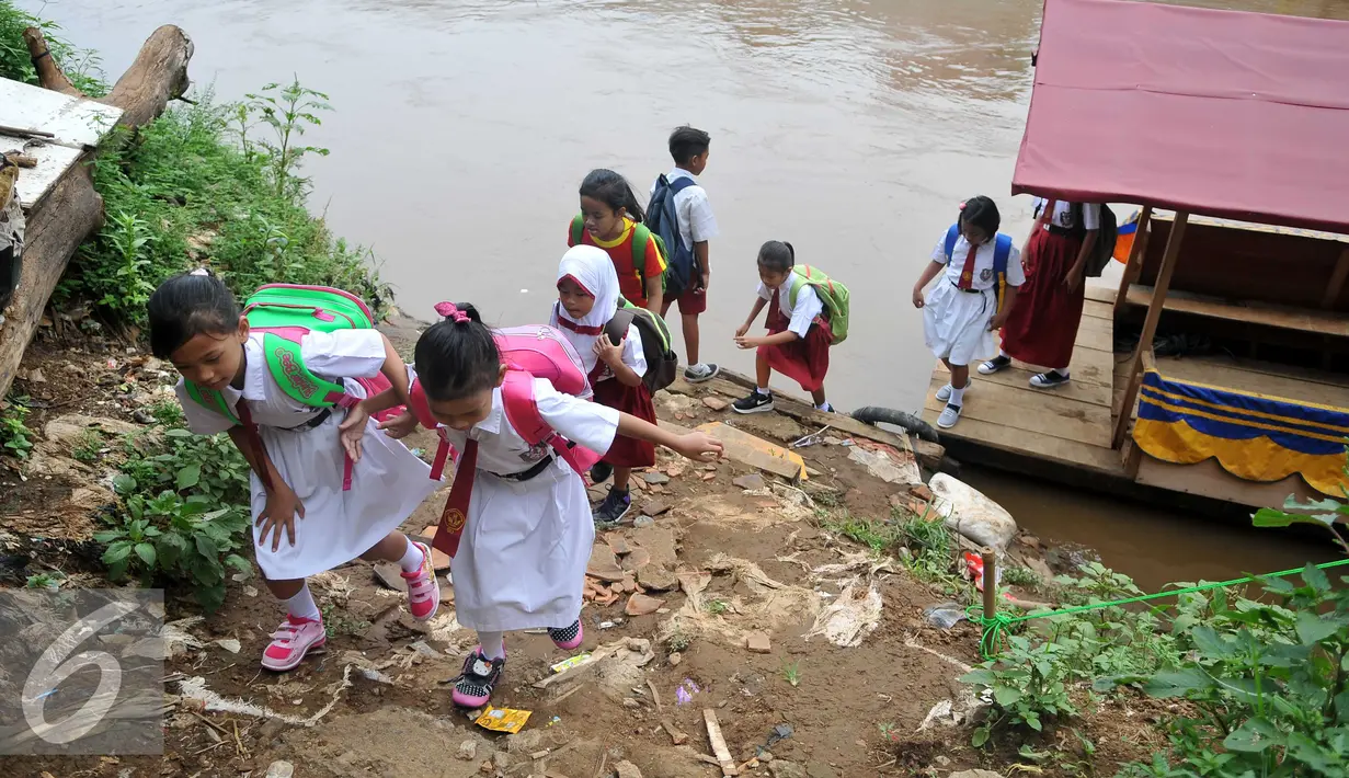Sejumlah siswa SD usai menaiki perahu eretan untuk berangkat ke sekolah di Sungai Ciliwung, Jakarta, Senin, (4/1). Usai libur panjang para siswa kembali beraktivitas mengikuti tahun ajaran 2016-2017. (Liputan6.com/Gempur M Surya)