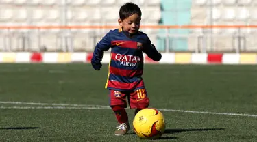 Murtaza Ahmadi (5) memakai jersey Barcelona bernama Messi saat bermain sepak bola di markas Federasi Sepak Bola Afghanistan di Kabul , Afghanistan, (2/2). Bintang Barcelona Lionel Messi dikabarkan akan bertemu dengan bocah ini. (REUTERS / Omar Sobhani)