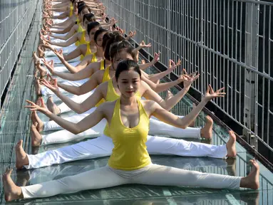 Sejumlah wanita melakukan yoga di jembatan kaca di Taman Nasional Shiniuzhai di Pingjiang, provinsi Hunan, China, Kamis (5/11). Latihan ekstrem di atas ketinggian 180 meter ini untuk mempromosikan hidup sehat dengan beryoga. (REUTERS/China Daily)