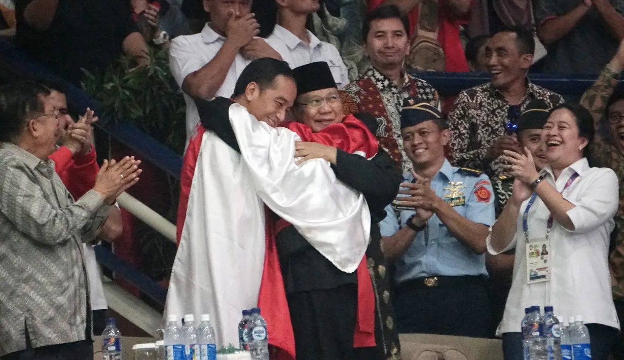 Presiden Joko Widodo atau Jokowi dan Ketua Umum Pengurus Besar Ikatan Pencak Silat Indonesia (IPSI) Prabowo Subianto memeluk atlet pencak silat Hanifan Yudani di Jakarta, Rabu (29/8). (ANTARA FOTO/Kumparan/INASGOC/Aditia Noviansyah/pras/18)