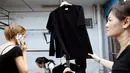 Warga membeli T-shirt hitam untuk acara berkabung atas meninggalnya Raja Thailand Bhumibol Adulyadej di Pasar Grosir Bo Bae Bangkok, Thailand (15/10). (REUTERS / Edgar Su)