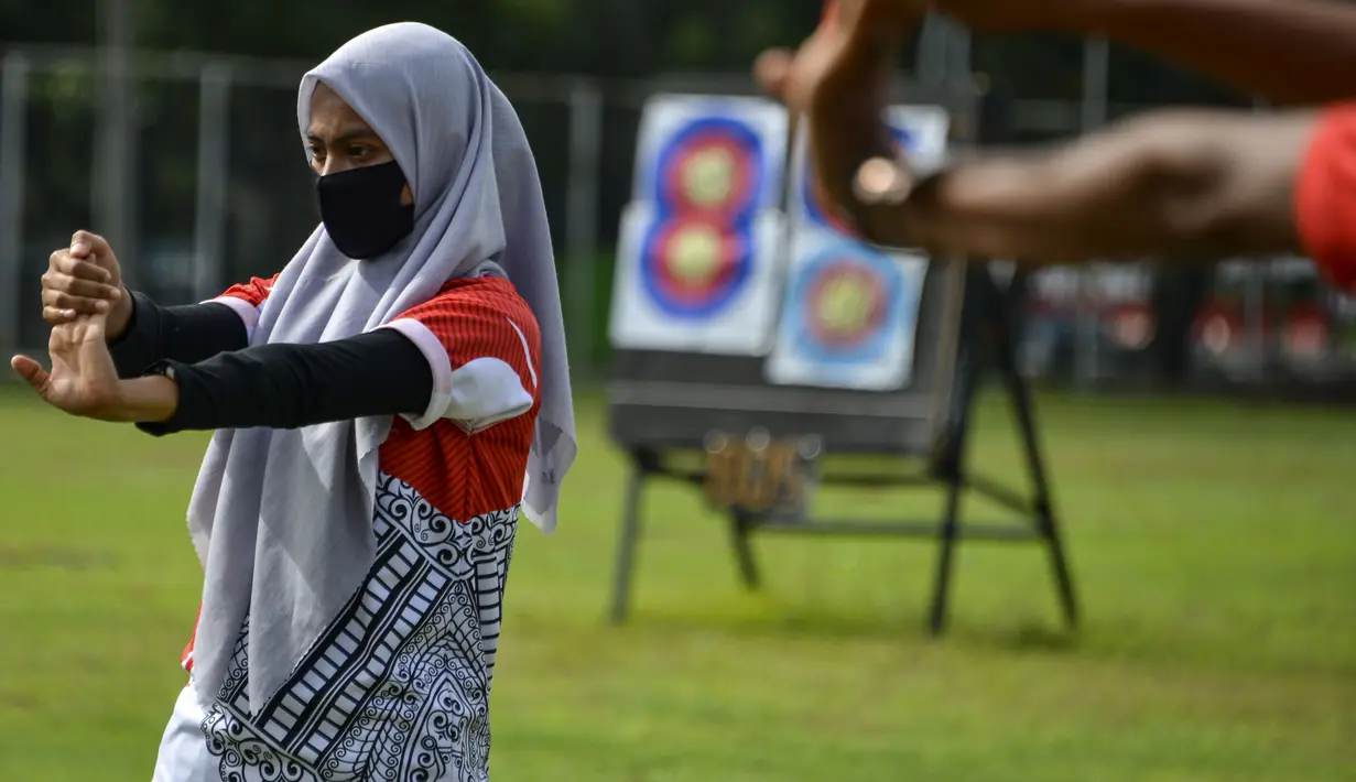 Pemanah dari tim provinsi Aceh melakukan pemanasan saat bmenghadiri sesi latihan di sebuah stadion di Banda Aceh (2/9/2020). (AFP Photo/Chaideer Mahyuddin)