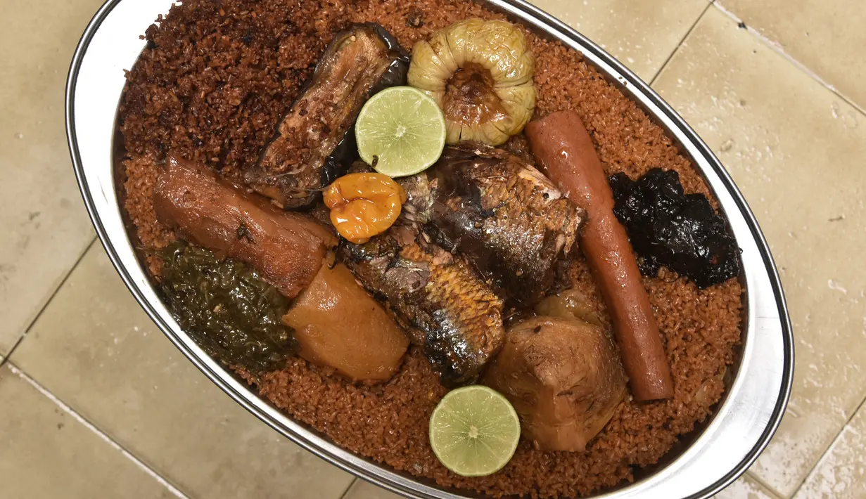 Thiebou dieune yang terbuat dari nasi, ikan, dan berbagai sayuran difoto di sebuah rumah di Parcelles Assainies di Dakar pada 15 Desember 2021. Kota Saint-Louis di Senegal utara diyakini sebagai tempat kelahiran thiebou dieune. (SEYLLOU/AFP)